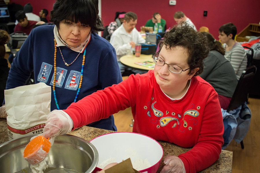 Female client pouring flour into a metal bowl