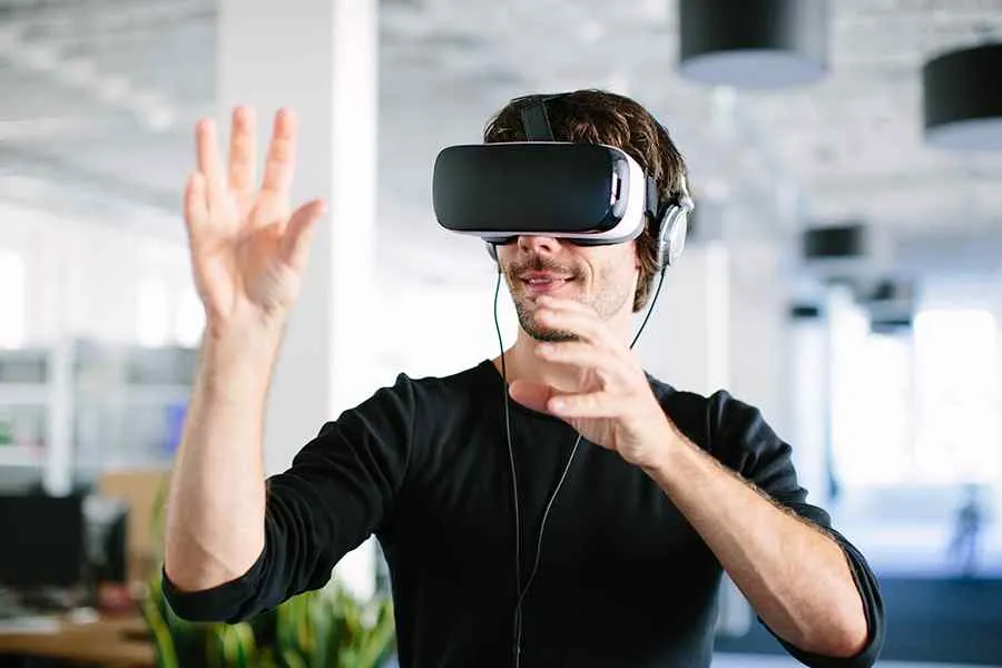 A man moving his hands while wearing VR goggles