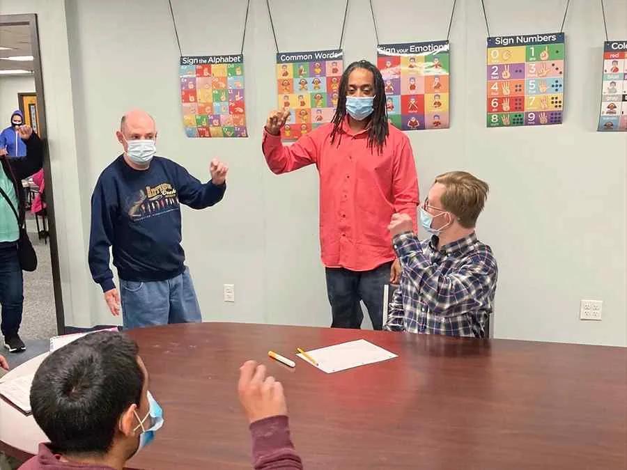 Clients and staff practicing sign language