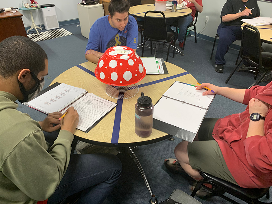 MARC clients sitting at tables doing work on worksheets